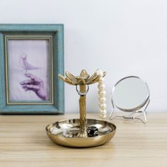 a gold plate with a cross on it next to a mirror and a framed photo