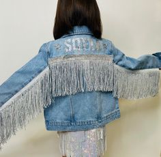 "Step into the spotlight with our \"Custom Starlight Fringe Denim Jacket,\" the perfect blend of classic denim and personalized pizzazz! This isn't just any denim jacket; it's your unique statement piece, waiting to be emblazoned with the name of your choice, showcased in glittering text accented by radiant stars. Product Description: Personal Touch: Highlight your individuality or give a gift that truly resonates by customizing the jacket with a chosen name, expertly adorned across the back. Tw Fringe Denim Jacket, Aesthetic Pose, Denim Jacket Outfit, Glitter Text, Classic Denim Jacket, Fringe Jacket, Western Dresses, Girls Jacket, Concert Outfit