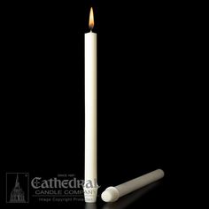 a white candle is lit on a black background