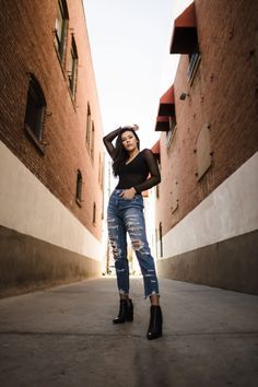 a woman is standing in an alley way