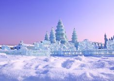 an ice castle with snow on the ground and blue sky in the backround