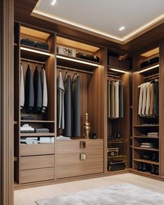 a large walk in closet with lots of clothes on shelves and lights above the doors