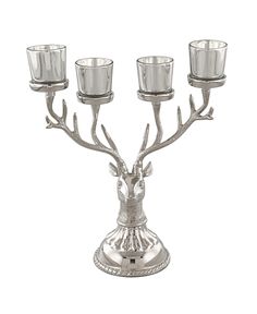 a metal candelabra with three candles in it and a deer head on the top