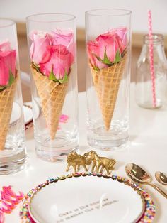 three ice cream cones with pink roses in them