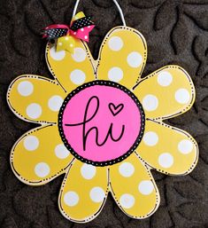 a yellow and white flower with the letter h on it's center is decorated with polka dots