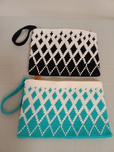 two purses sitting next to each other on top of a white floor with blue and black designs