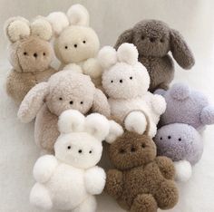 a pile of stuffed animals sitting next to each other on a white surface in front of the camera