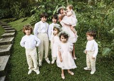 a group of young children standing next to each other on top of a lush green field