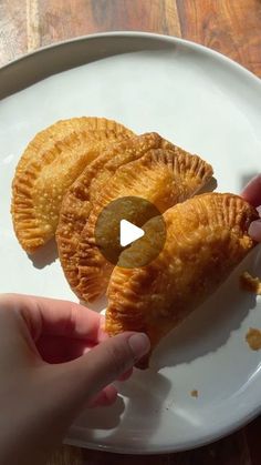 two pieces of pie on a plate being held up by someone's hand with the other