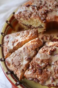 a plate that has some kind of cake on it with icing and pecans