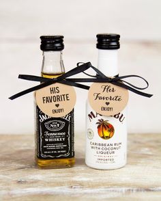 two bottles of alcohol tied to each other on top of a wooden table with black ribbon