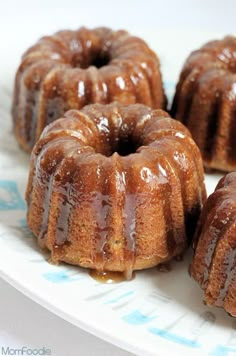 three bundt cakes sitting on top of a white plate covered in chocolate glaze