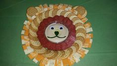 a lion head made out of crackers on a green tablecloth covered table cloth