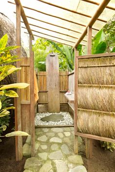 an outdoor shower area with stone steps and grass covering the walls, surrounded by greenery