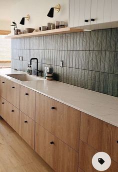 a kitchen with wooden cabinets and white counter tops, black handles on the faucet