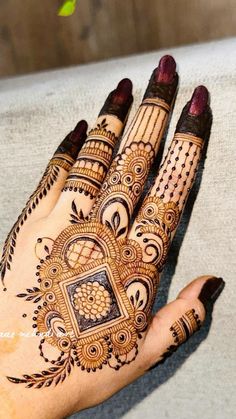 a woman's hand with henna tattoos on it