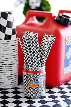 some black and white checkered paper straws are in a jar on a table