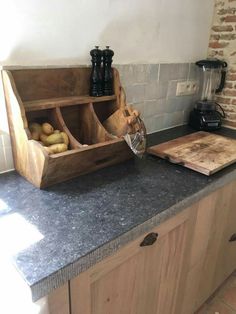 a kitchen counter with cutting board and wooden utensils