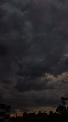 the sky is filled with dark clouds and buildings