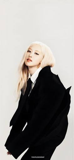 a woman with blonde hair wearing a black suit and white shirt is posing for the camera