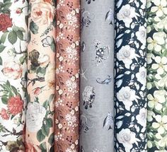 several different types of fabric with flowers and leaves on them, all in various colors