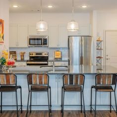 the kitchen is clean and ready to be used for cooking or eating, with three bar stools in front of the island