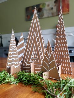 three brown and white christmas trees sitting on top of a wooden table