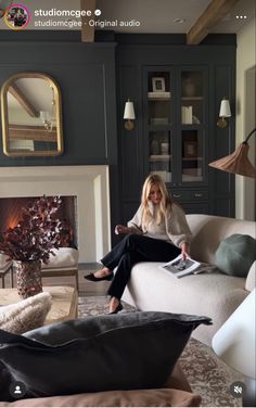 a woman walking through a living room filled with furniture