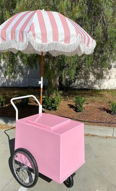 a pink ice cream cart with an umbrella