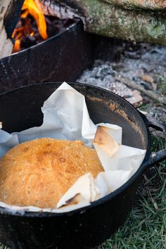 bread is sitting in a pan next to an open fire