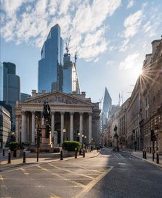 the sun shines brightly on an empty street in front of tall buildings and skyscrapers