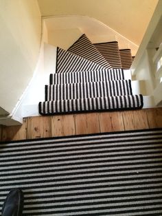 a black and white striped rug is on the stairs