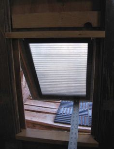 an open window with a ruler in front of it and some wood on the floor