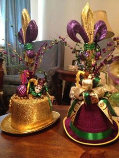 there are two hats that have decorations on top of them, one is gold and the other is purple