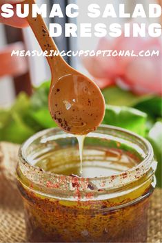 a spoon full of sunflower seed dressing being drizzled over the jar