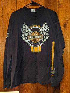 a harley davidson shirt hanging on a wooden wall