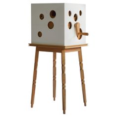 a wooden table with a white cube on it and holes in the side that are cut out