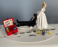 a bride and groom figurine sitting on top of a table next to an open box