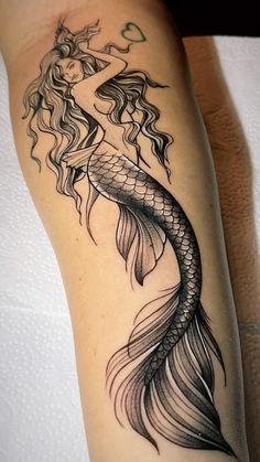 a woman's leg with a black and white tattoo design on the side of it