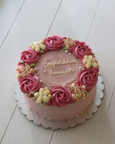 a cake with pink frosting and flowers on top