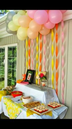 an image of a party with balloons on the wall and food on the table in front of it