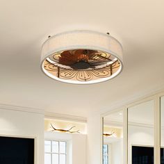 a bathroom with two sinks, mirrors and a round light fixture in the middle of the room