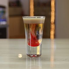 a shot glass filled with liquid sitting on top of a table