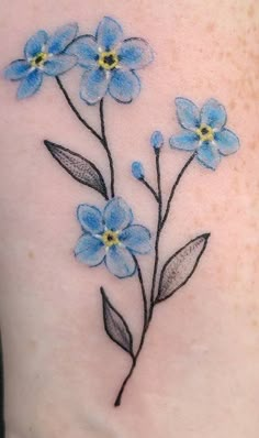 a blue flower tattoo on the back of a woman's stomach