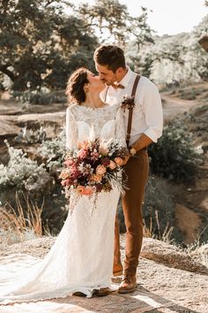 a bride and groom kissing in the desert