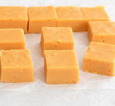 several squares of yellow cake sitting on top of wax paper