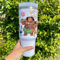 a person holding up a white tumbler cup with an image of a bigfoot on it