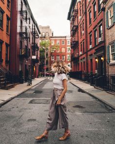 a woman walking down the middle of an empty street