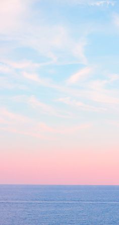 two people on surfboards in the ocean at sunset, with pink and blue sky