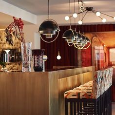 a bar with chairs and vases on the counter